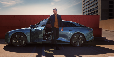 A man walking out of a Lucid Air driver side door.