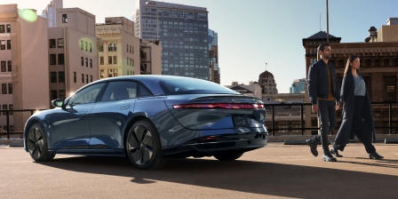 A couple coming walking away from a Lucid Air.