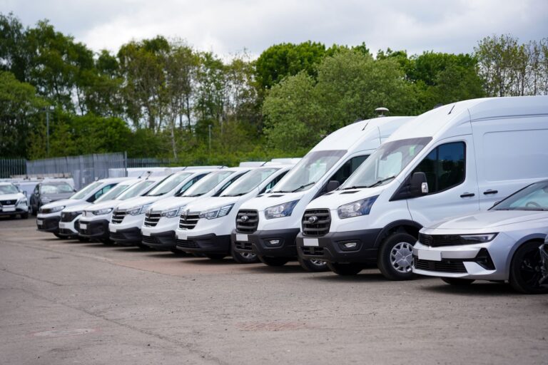 A fleet of white vans in a row
