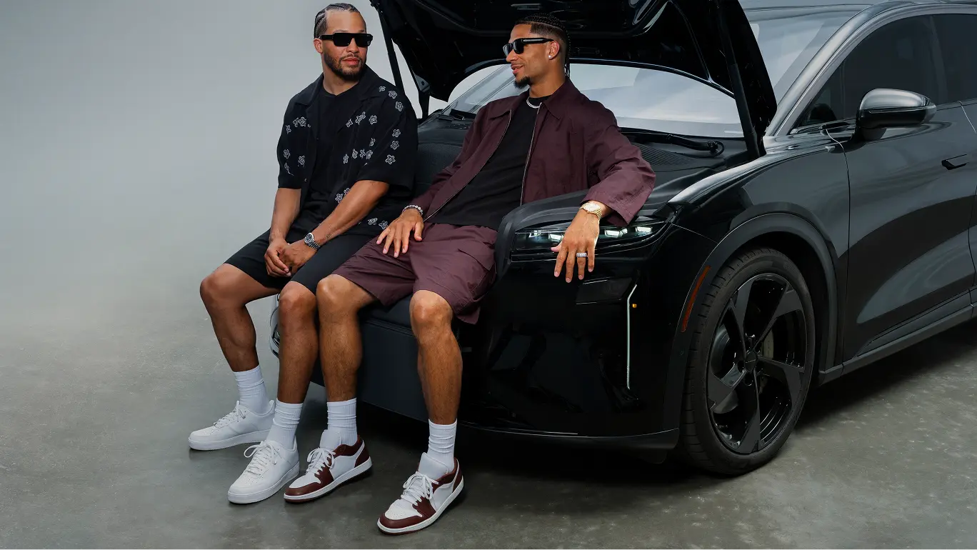 Josh Hart and Jalen Brunson sitting in the frunk of a Lucid Gravity