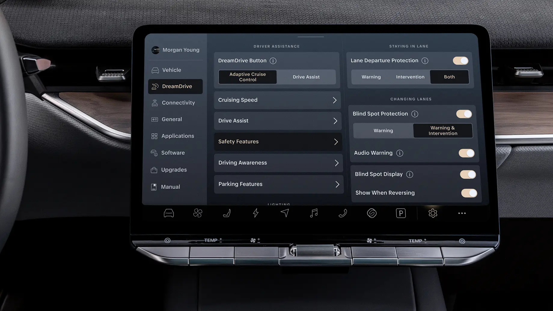Dark car touchscreen displaying DreamDrive driver assistance settings, including lane departure and blind spot protection toggles.