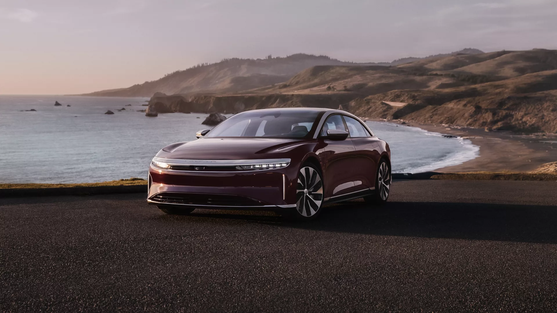 Lucid Air in Zenith Red infront of bay