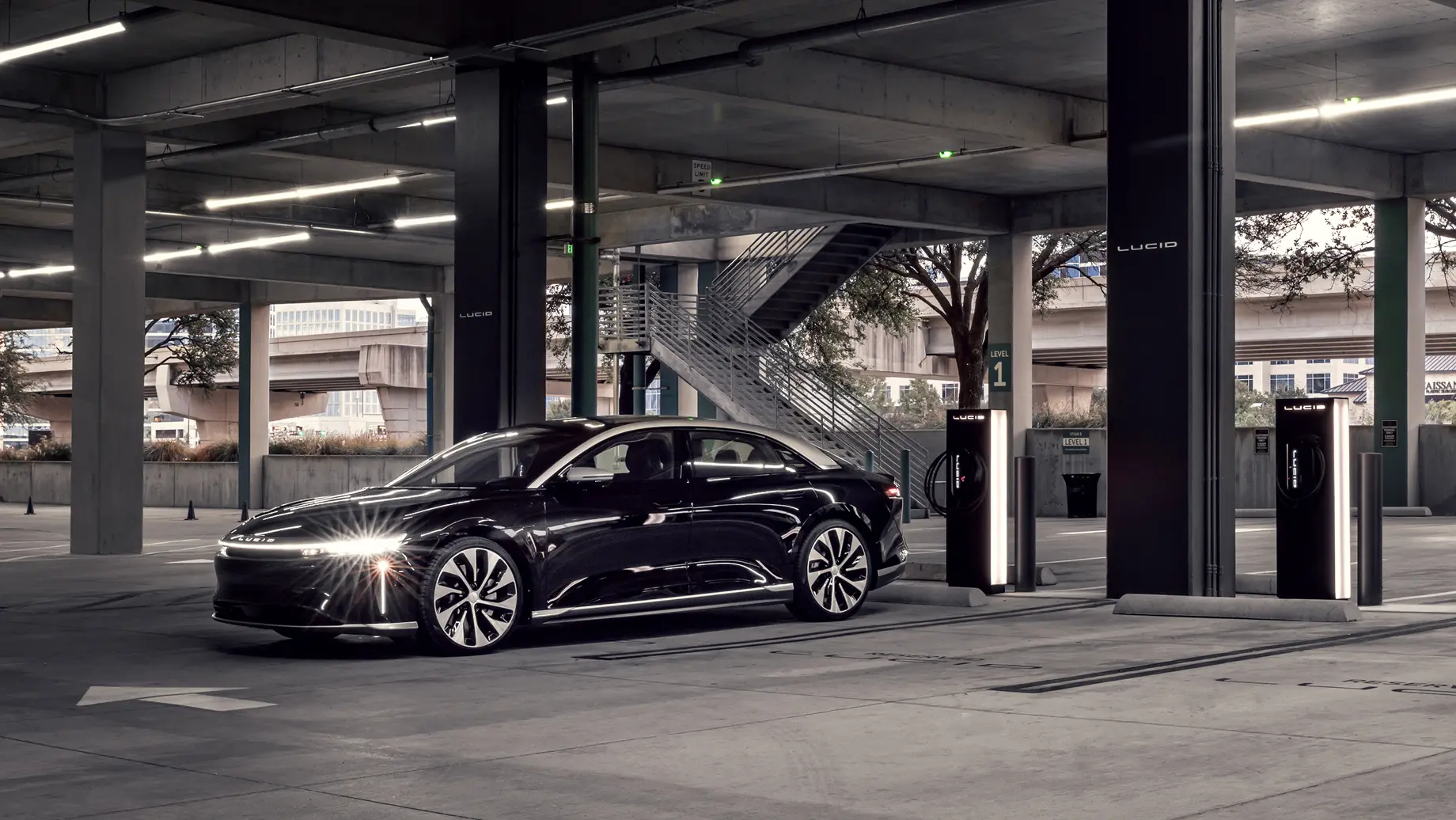 Infinite Black Metallic Lucid Air in parking garage, charging.