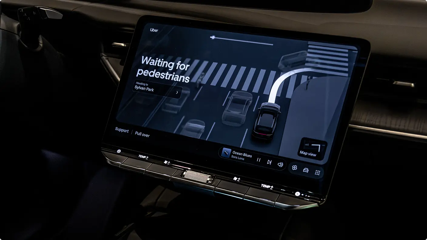 Car dashboard screen displaying an Uber autonomous driving interface with "Waiting for pedestrians" message and a top-down map view.